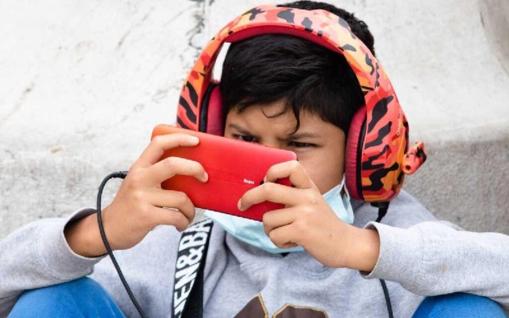 Child wearing headphones using a smartphone