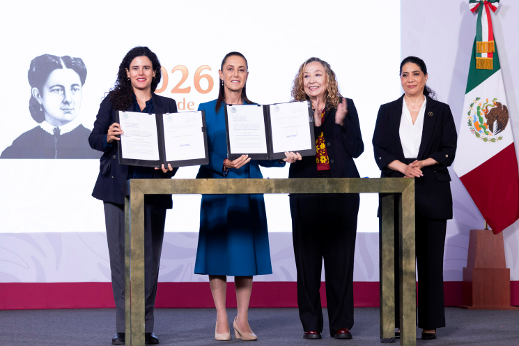 Sheinbaum holds up the signed initiative alongside government officials at the National Palace.