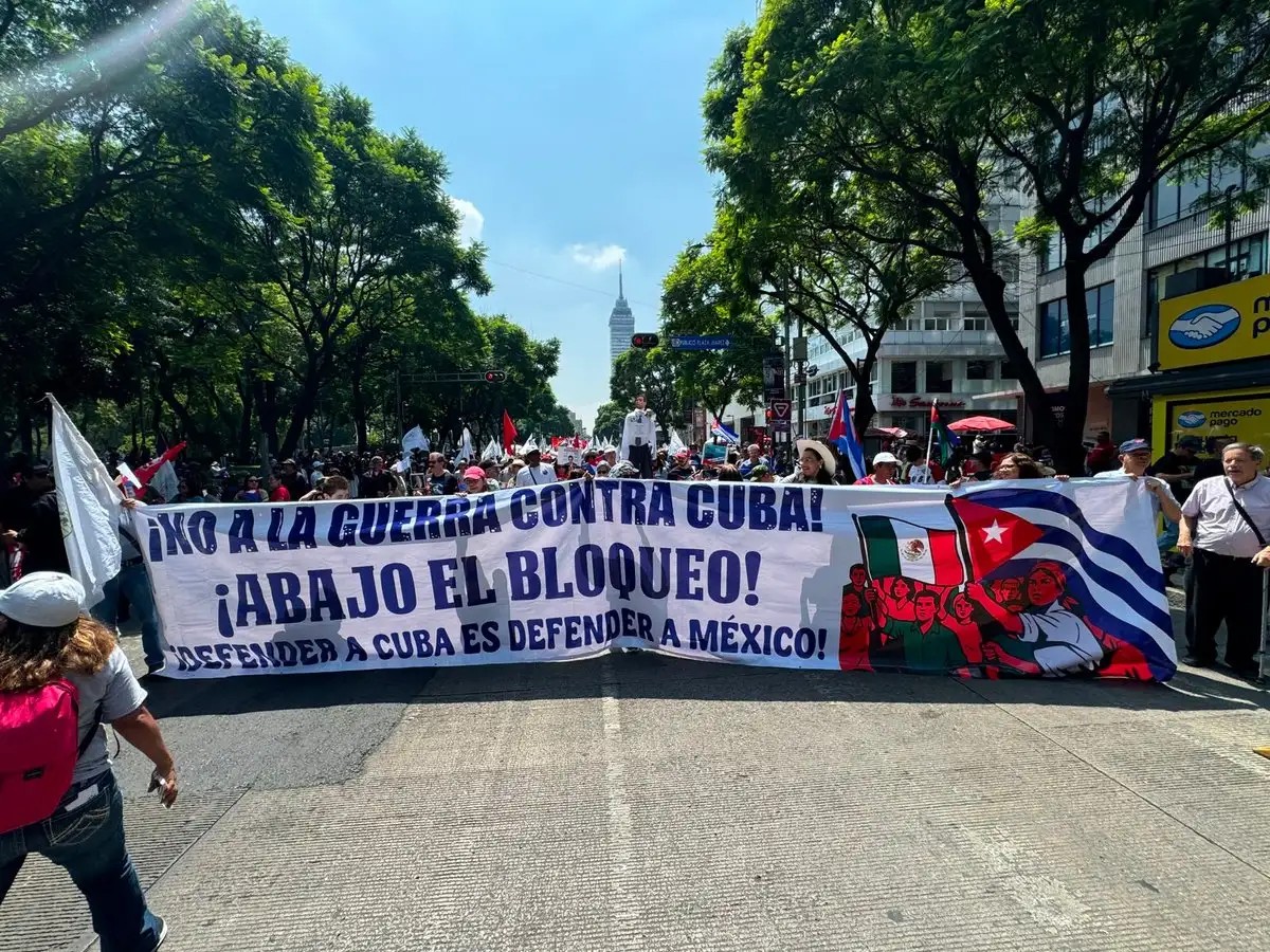 Marchers hold a banner reading 'No to the war against Cuba! Down with the blockade! To defend Cuba is to defend Mexico!'