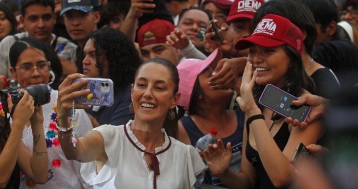 President Claudia Sheinbaum takes selfies with supporters at a Morena rally