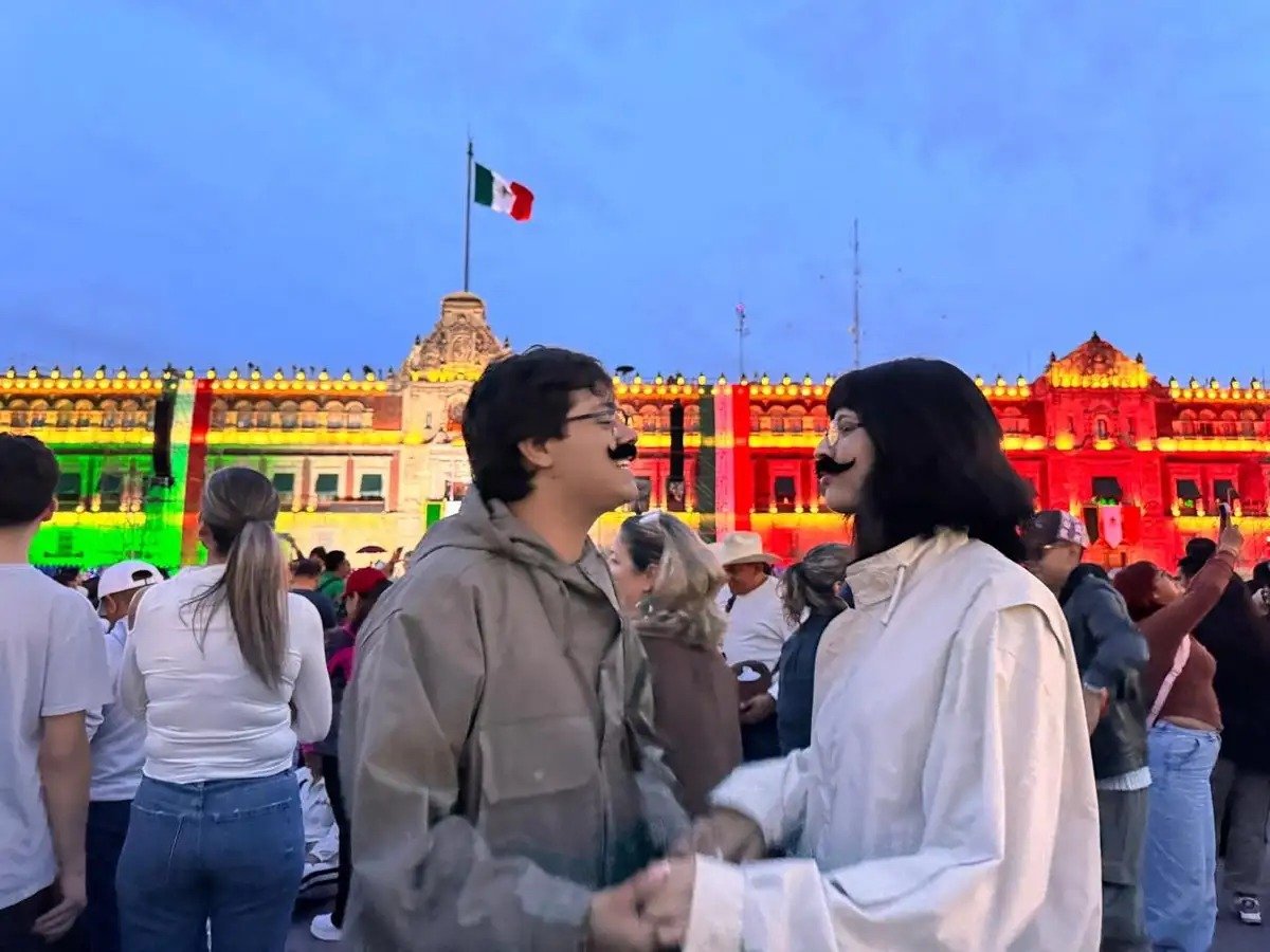 Revelers in front of the National Palace lit in tricolor