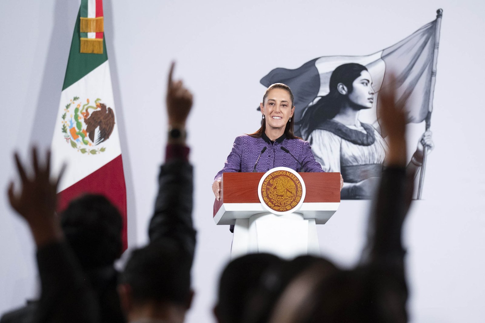President Claudia Sheinbaum smiles at the podium during her morning press conference at the National Palace as reporters raise their hands, September 30, 2026.