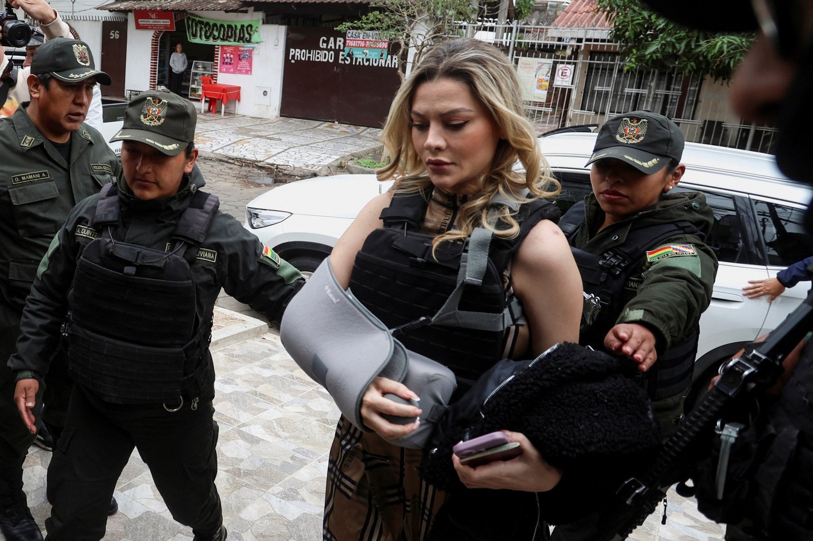 Nadia Beller in a bulletproof vest escorted by Bolivian police