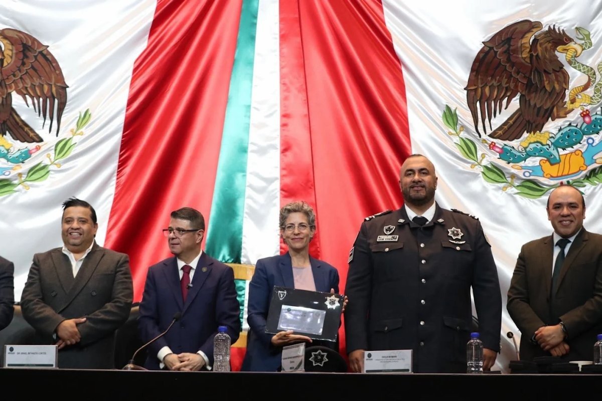 Israeli embassy attaché Dahlia Neumann holds an award in the Chamber of Deputies alongside PRI deputy Israel Betanzos