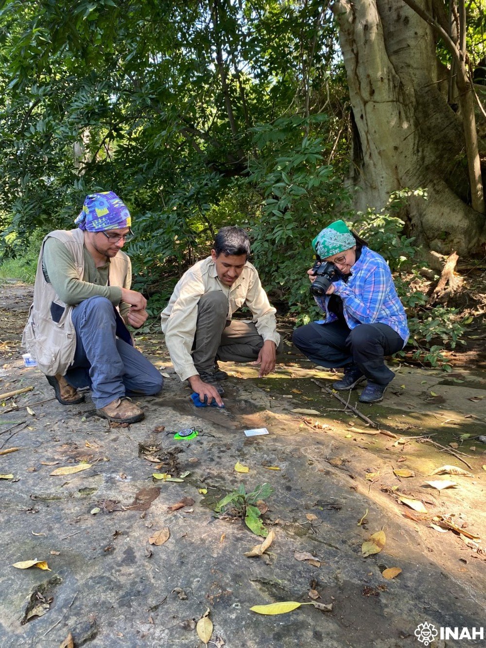 INAH specialists examining the footprints at the site