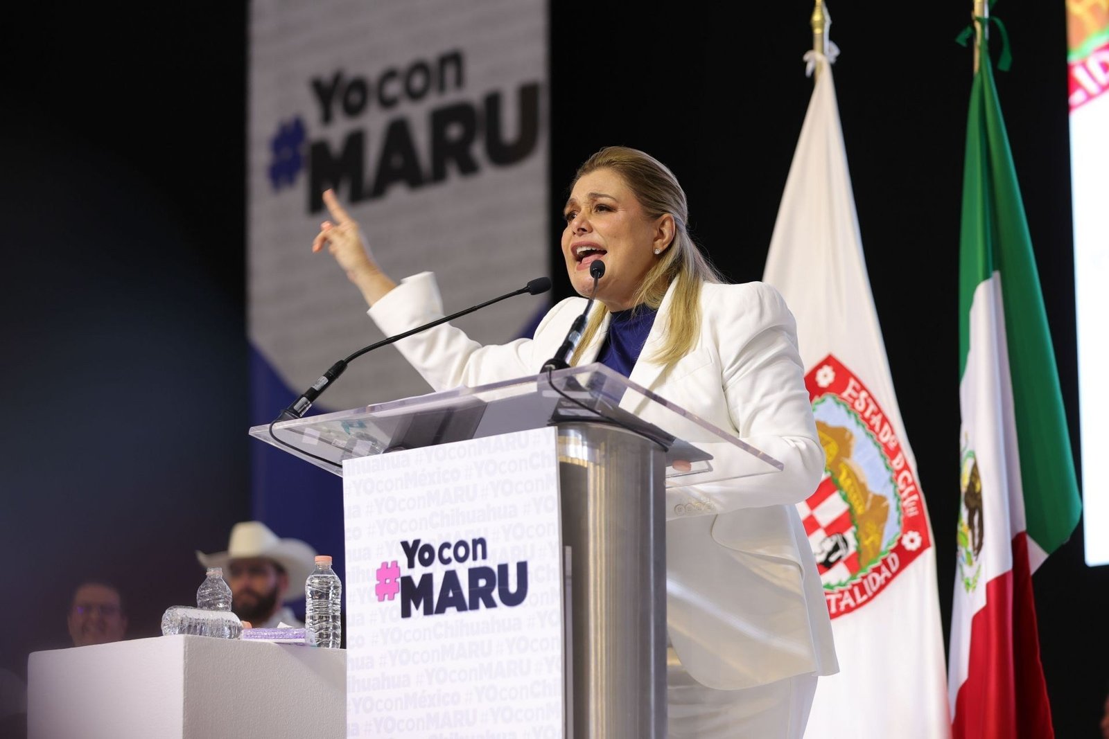 Chihuahua Governor Maru Campos speaks at a podium at a 'Yo con Maru' event